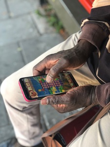 An over 45+ gaming whilst waiting for his bus. 